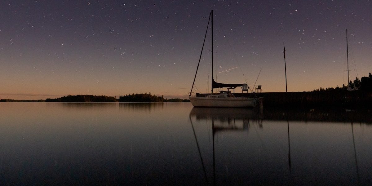 white boat on calm water under starry night