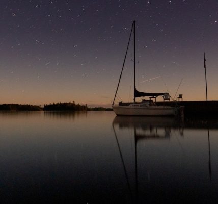 white boat on calm water under starry night
