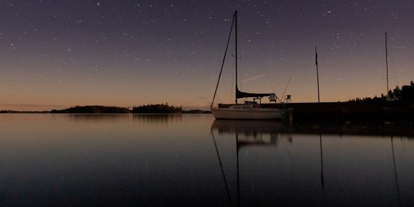white boat on calm water under starry night
