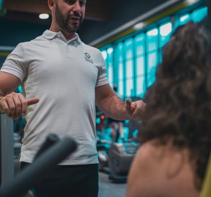 Sesión de entrenamiento en el gimnasio con un entrenador personal, enfocada en el rendimiento y el bienestar físico.